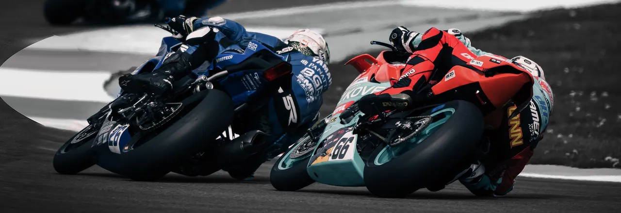 Two riders leaned over on a racetrack